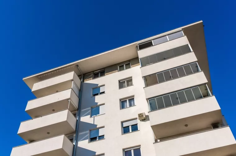 Zagreb, Croatia, October 20th, 2024A modern residential building featuring balconies with glass railings and a beige facade under a clear sky in Zagreb.Zagreb, stanovi. zgrada, zgrade, priuštivo stanovanje